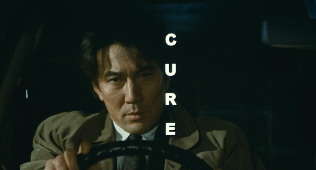 Detective Takabe drives through the city at night in Cure (1997).