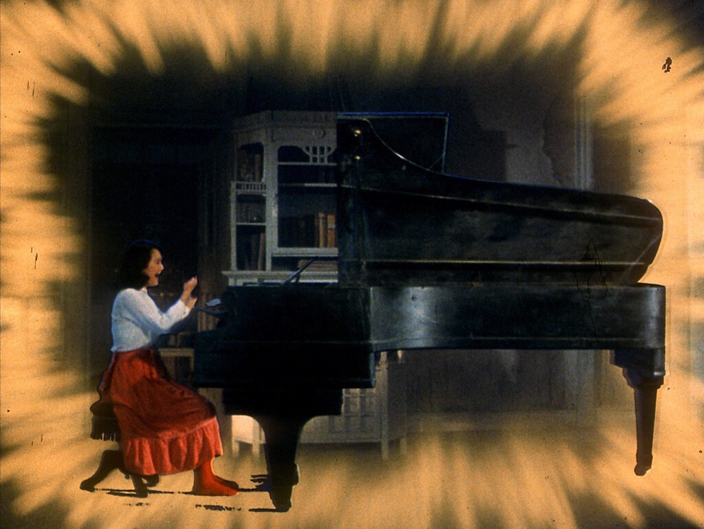 A girl sits at a grand piano surrounded by surreal visual effects in House (1977).