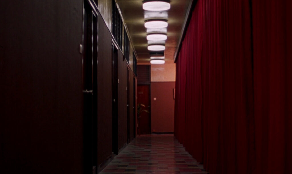 A red hotel corridor in In the Mood for Love (2000), showcasing Wong Kar-wai's iconic visual style.