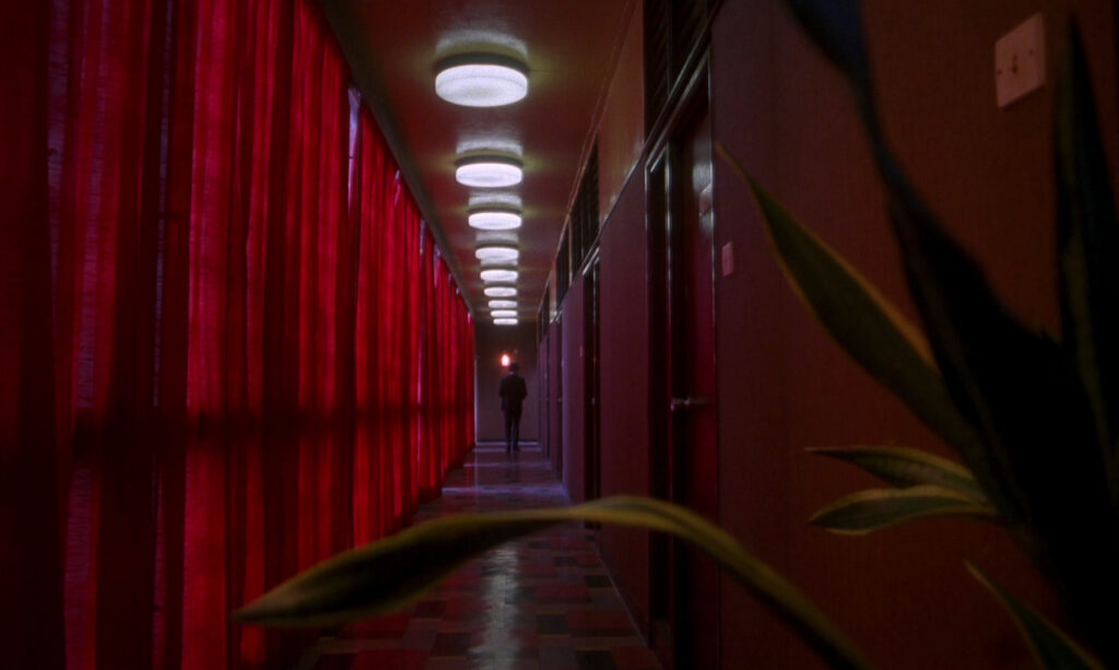 The striking red hallway in In the Mood for Love (2000) creates a sense of distance and longing.