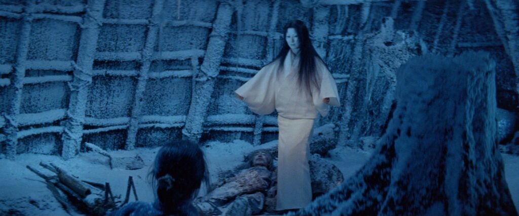 A ghostly woman in a white kimono stands in a snow-covered village in Kwaidan (1964).