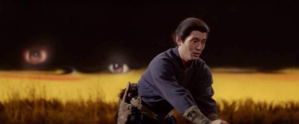 A samurai walks through a golden field beneath a dramatic sunset in Kwaidan (1964).