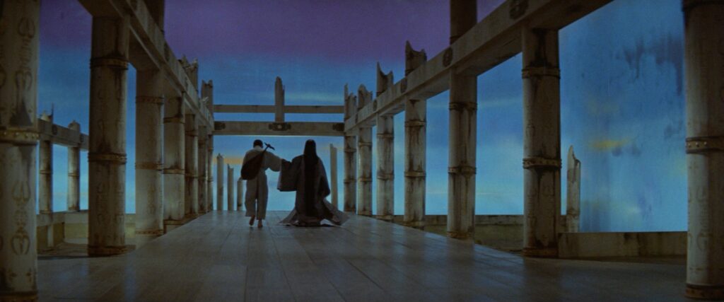 Two figures walk through a grand palace corridor in Kwaidan (1964).