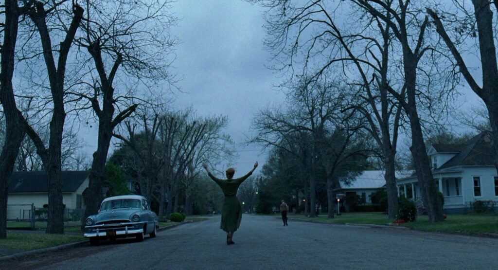 Jessica Chastain walks down a quiet suburban street in The Tree of Life (2011).