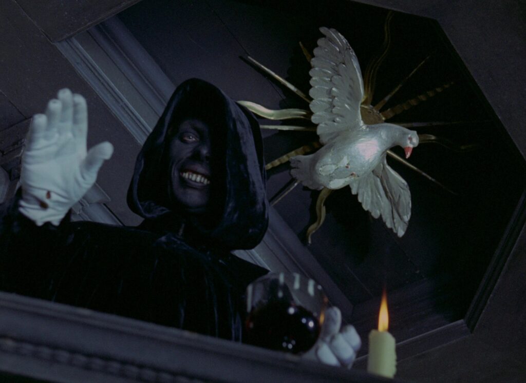 A hooded figure reaches toward a white dove in Valerie and Her Week of Wonders (1970).