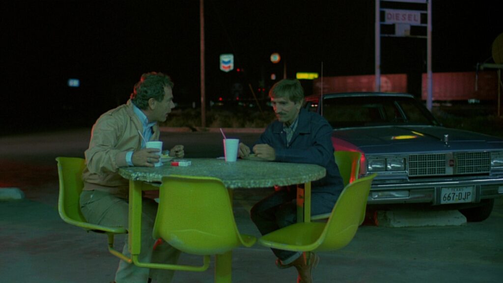 Father and son reconnect during a nighttime roadside meal in Paris, Texas (1984).