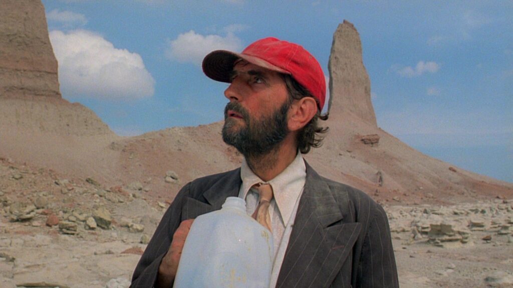 Harry Dean Stanton as Travis Henderson in the vast desert landscape of Paris, Texas (1984).