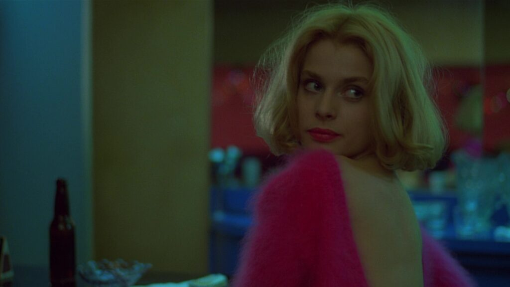 Jane appears under soft neon light in Paris, Texas (1984), highlighting the film's dreamlike atmosphere.