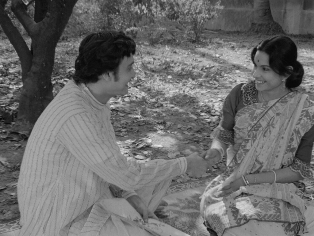 Amal and Charulata share an easy, warm conversation in the garden, in Charulata (1964)