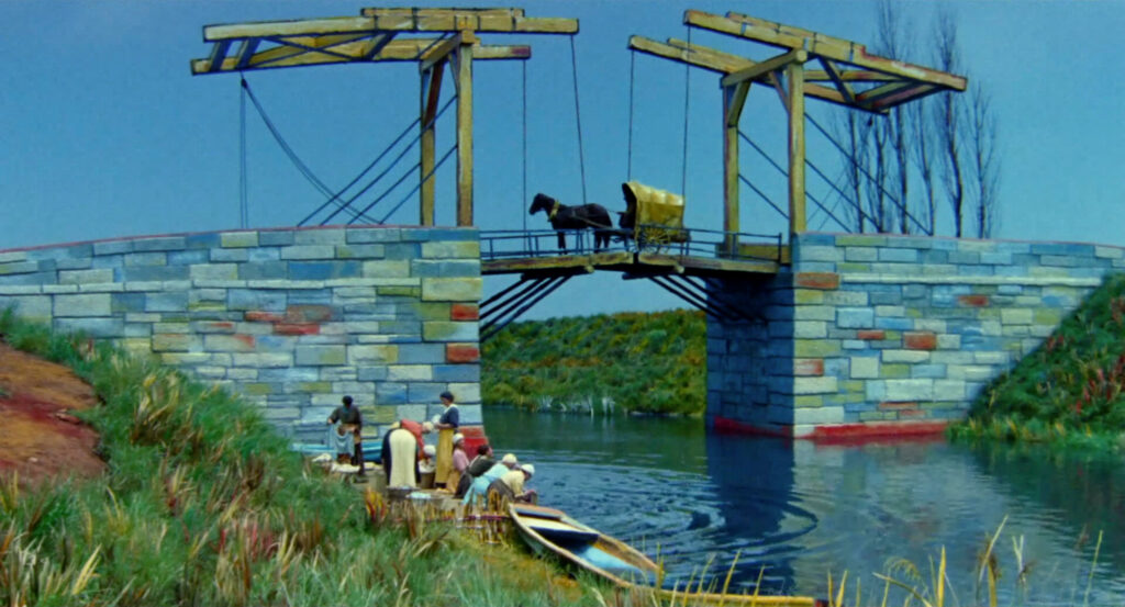 A horse-drawn carriage crosses a stone bridge over a quiet river in Dreams (1990).