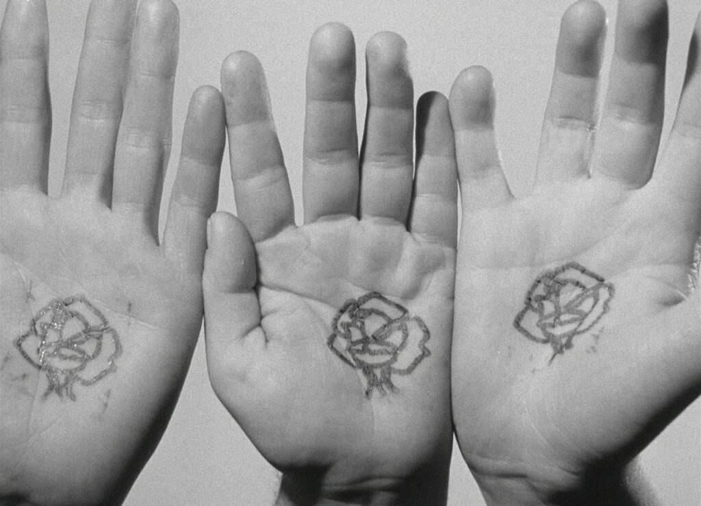 Three hands display matching rose tattoos in Funeral Parade of Roses (1969).
