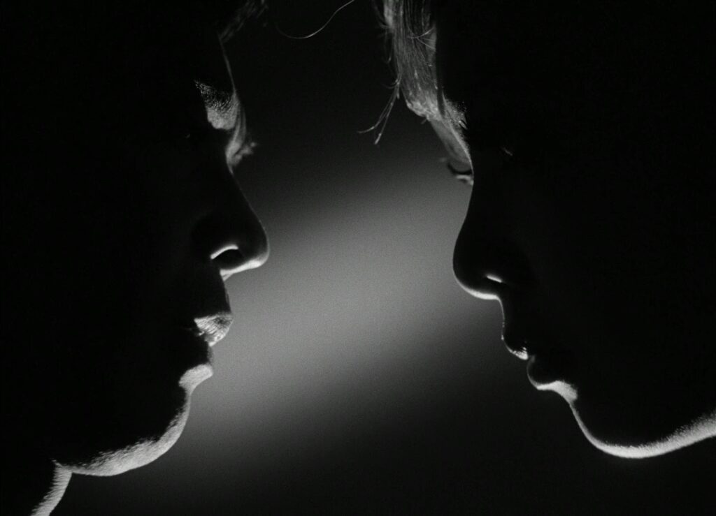 Two faces meet in dramatic profile lighting in Funeral Parade of Roses (1969).