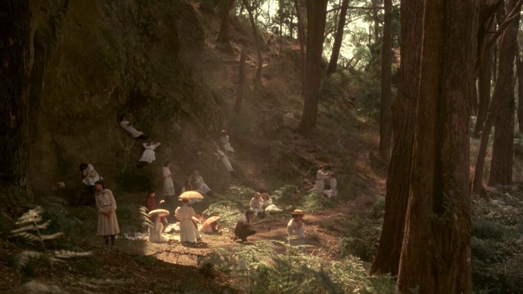 Wide shot of the picnic beneath the cliffs of Hanging Rock in Picnic at Hanging Rock (1975)