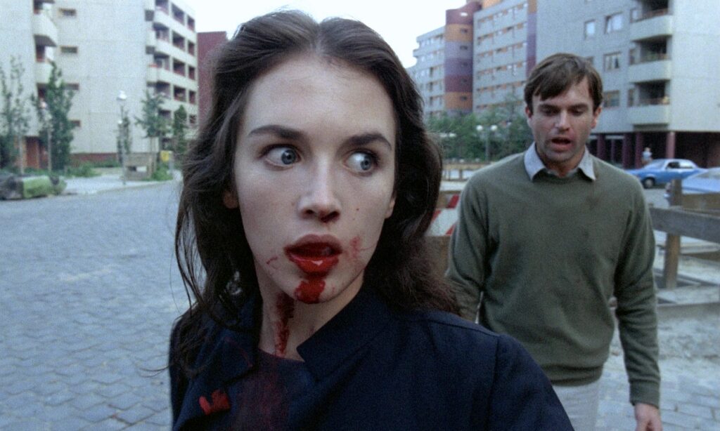 Isabelle Adjani with blood on her face walking through a Berlin housing complex in Possession 1981
