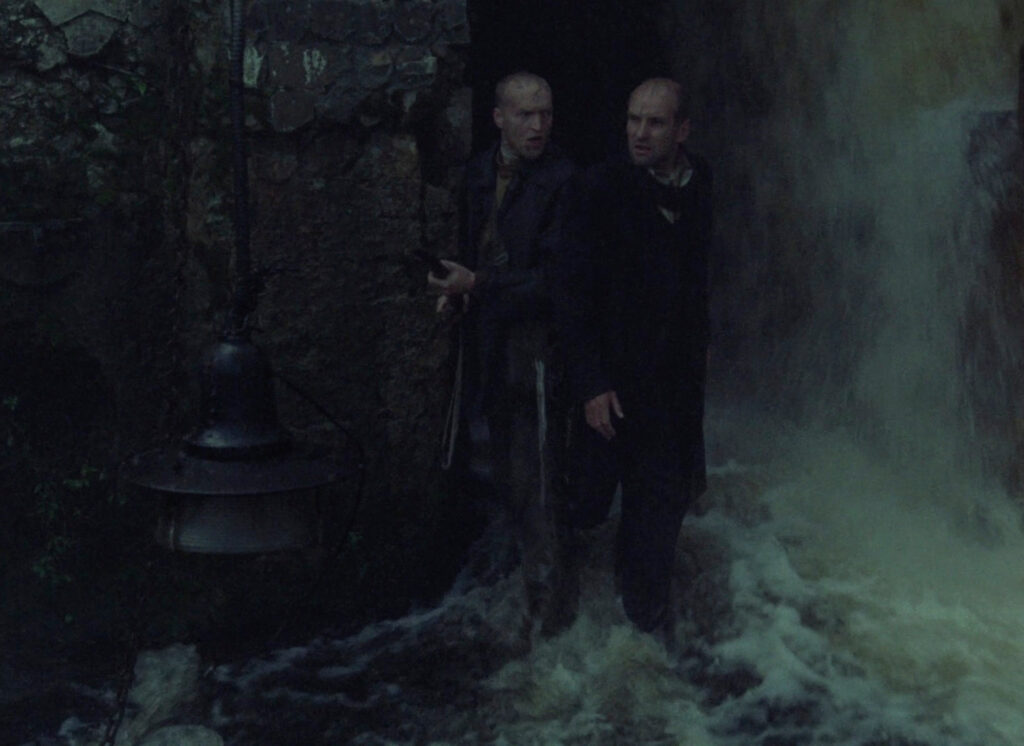 The Stalker and Writer pause at a threshold deep within the Zone in Stalker (1979)