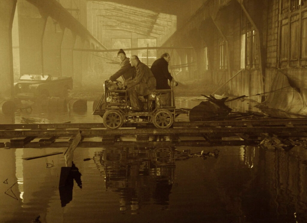 The Stalker, Writer, and Professor ride a handcar into the Zone in Tarkovsky's Stalker (1979)