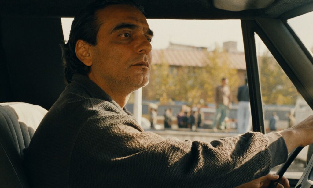 Taste of Cherry (1997): A Film About Wanting to Die That Makes You Want to Live Taste of Cherry 1997 Review 1 Mr. Badii driving through Tehran in Taste of Cherry (1997), Abbas Kiarostami film
