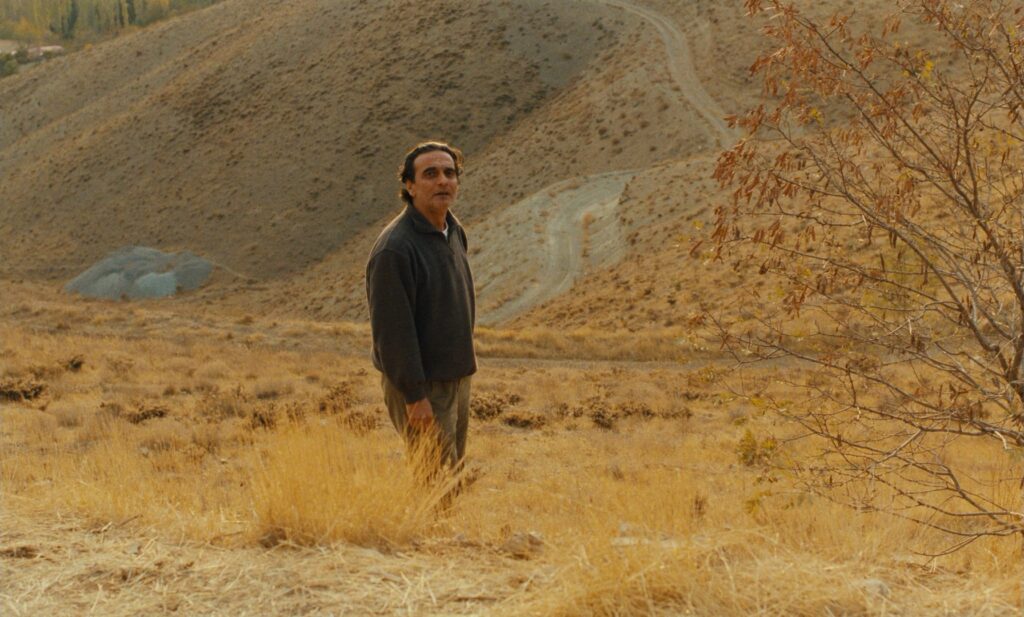 Taste of Cherry (1997): A Film About Wanting to Die That Makes You Want to Live Taste of Cherry 1997 Review 2 Man standing alone on the dusty hillsides in Taste of Cherry (1997)
