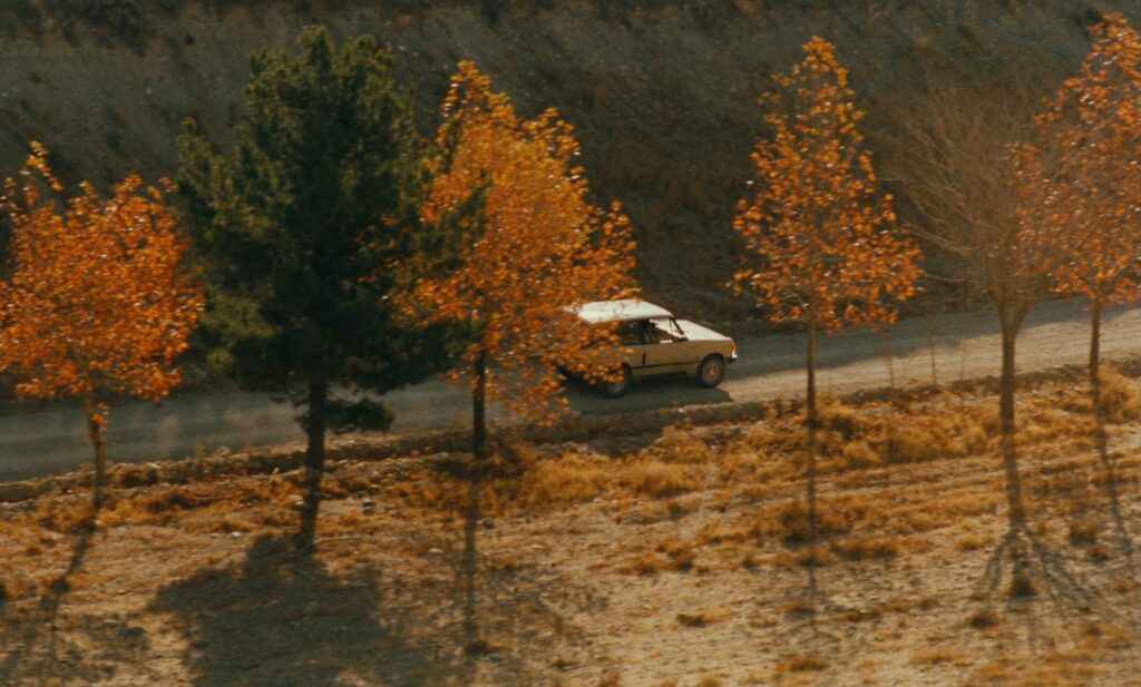 Taste of Cherry (1997): A Film About Wanting to Die That Makes You Want to Live Taste of Cherry 1997 Review 4 Mr. Badii's Range Rover driving past autumn trees in Taste of Cherry (1997)