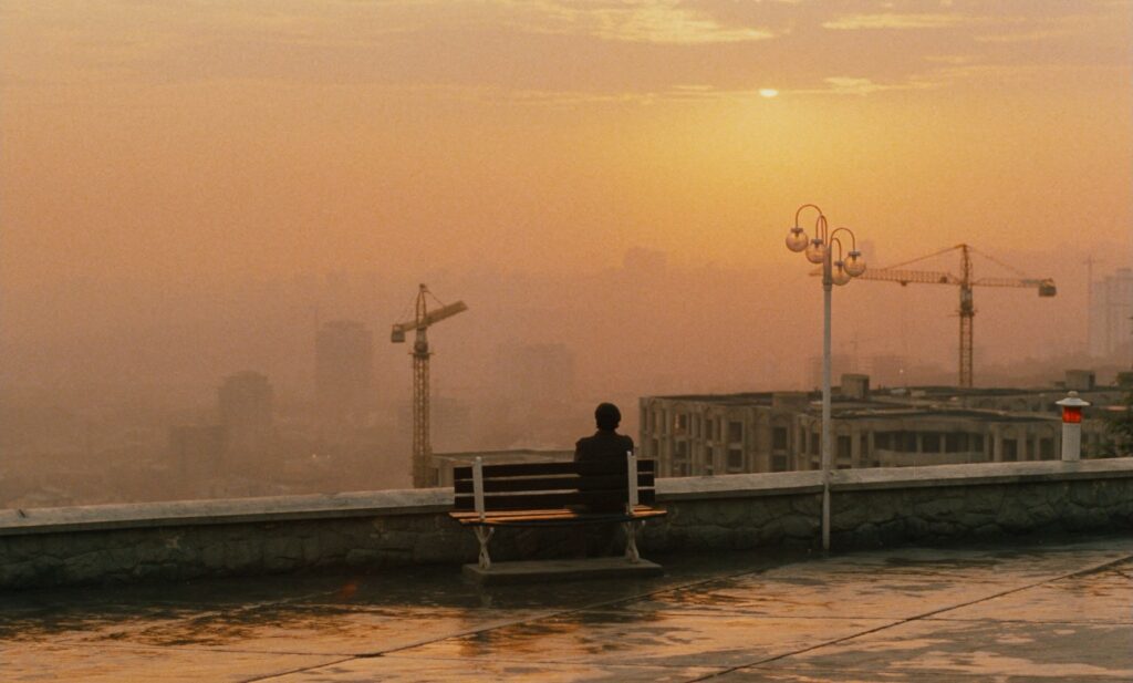 Taste of Cherry (1997): A Film About Wanting to Die That Makes You Want to Live Taste of Cherry 1997 Review 5 Silhouette on a bench overlooking Tehran at sunset, Taste of Cherry ending scene