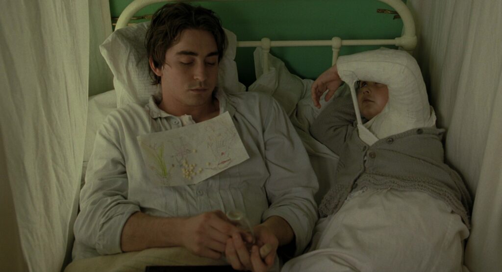 Lee Pace and Catinca Untaru in The Fall (2006) — a quiet, unscripted bedside moment between Roy and Alexandria