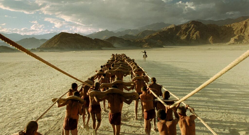 The Fall (2006) still — a striking desert procession scene highlighting Tarsem Singh's large-scale practical staging