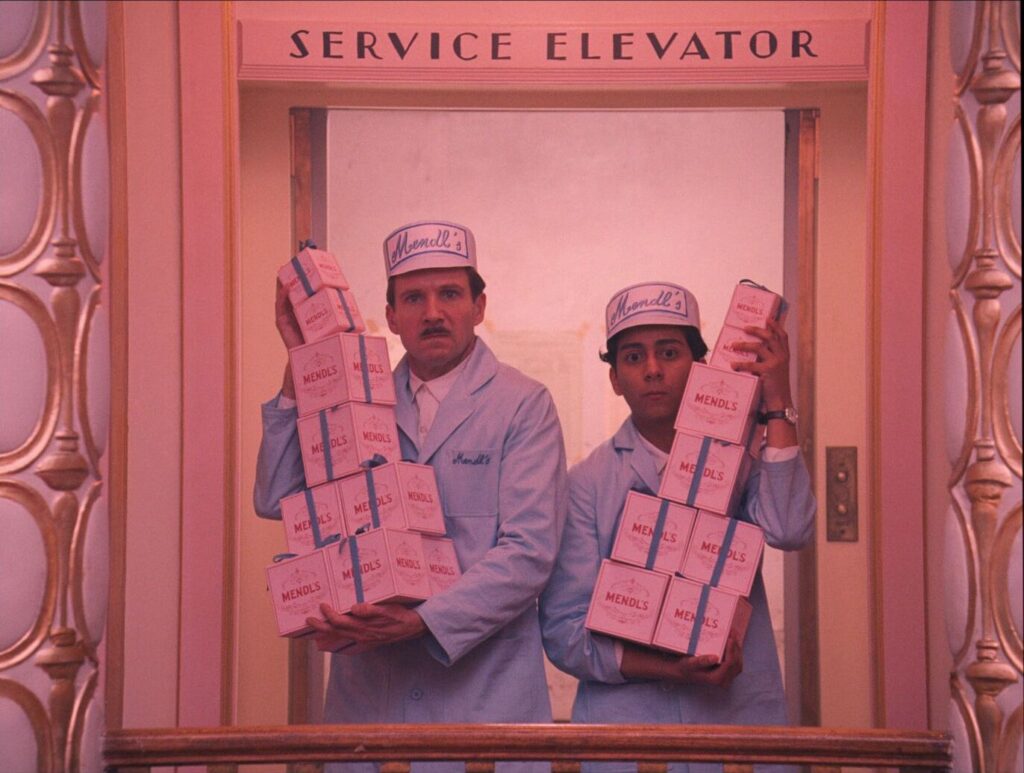 The Grand Budapest Hotel (2014) M. Gustave and Zero carrying stacks of Mendl's pastry boxes