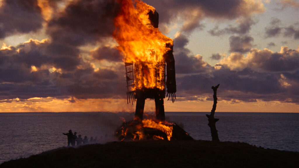 The towering wicker effigy burns at sunset overlooking the sea in The Wicker Man (1973).